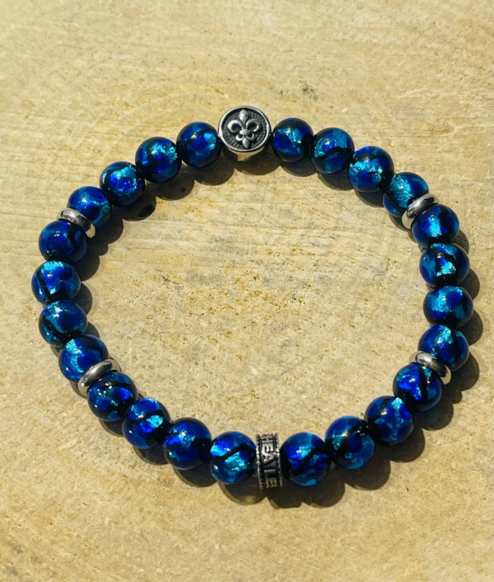 Bracelet en perles Lumineuses 8 mm bleues et fleur de lys - Les bijoux de Théa