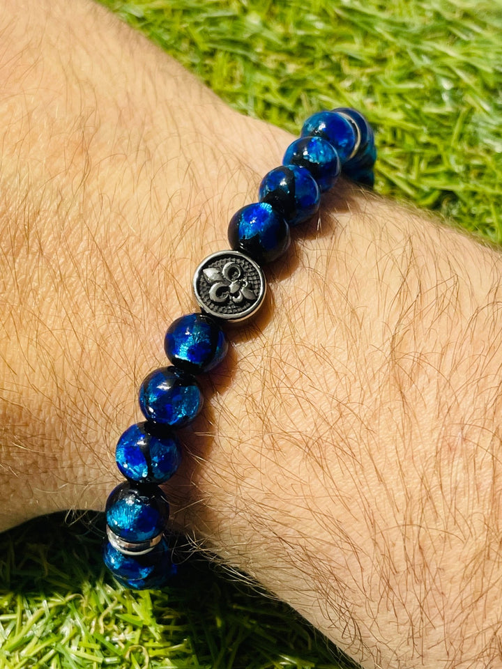 Bracelet en perles Lumineuses 8 mm bleues et fleur de lys - Les bijoux de Théa