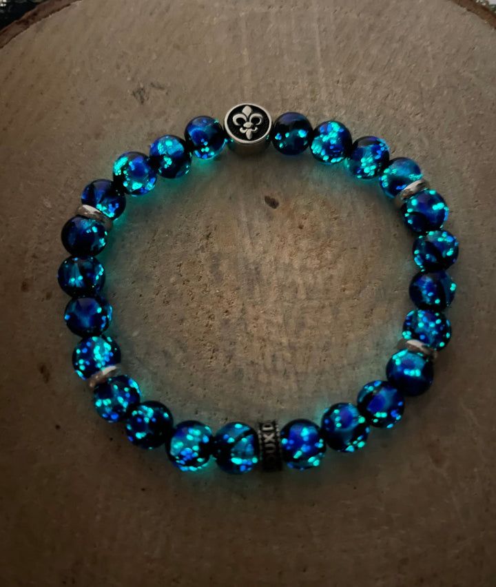Bracelet en perles Lumineuses 8 mm bleues et fleur de lys - Les bijoux de Théa