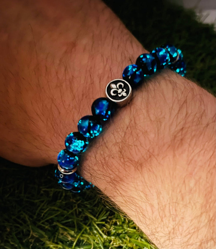 Bracelet en perles Lumineuses 8 mm bleues et fleur de lys - Les bijoux de Théa