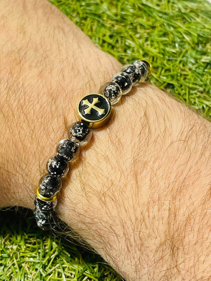 Bracelet en perles Lumineuses noires 8 mm avec croix dorée - Les bijoux de Théa