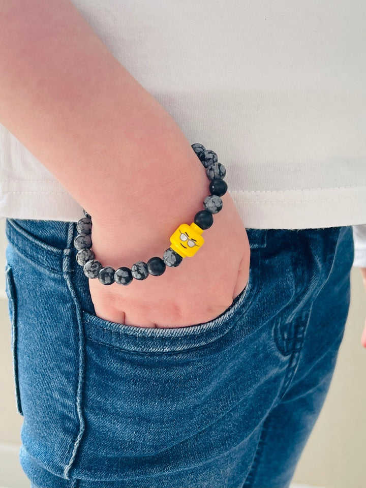 Bracelet pour enfant en perles naturelles 6 mm en Obsidienne Flocon et tête de Lego - Les bijoux de Théa