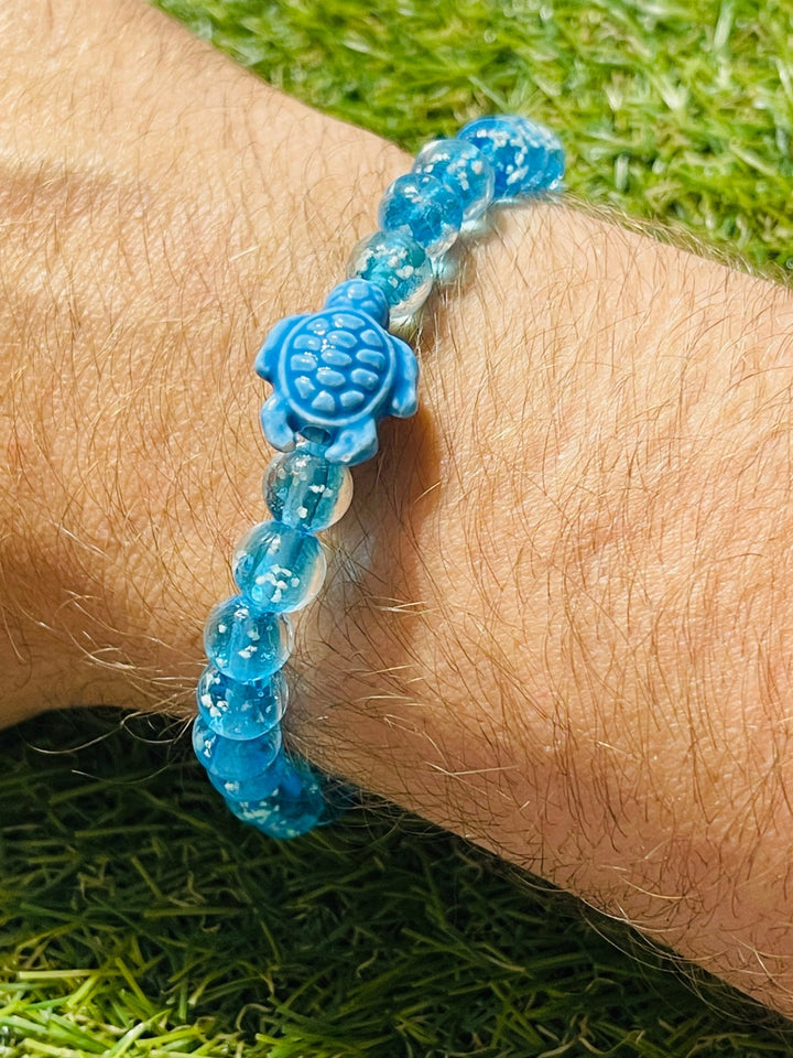 Bracelet "TORTUE" en perles Lumineuses bleues claires 8 mm et tortue - Les bijoux de Théa