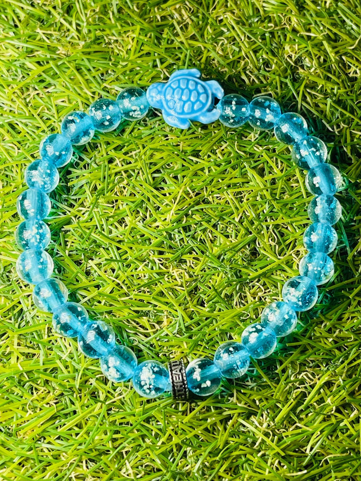Bracelet "TORTUE" en perles Lumineuses bleues claires 8 mm et tortue - Les bijoux de Théa
