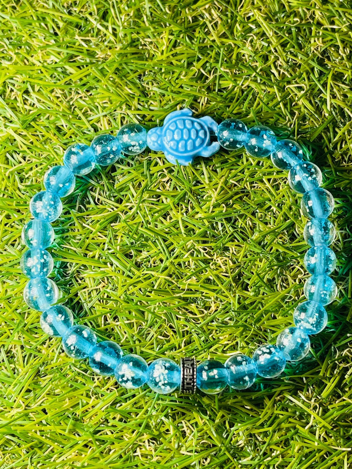 Bracelet "TORTUE" en perles Lumineuses bleues claires 8 mm et tortue - Les bijoux de Théa