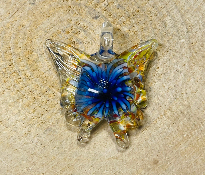 Pendentif en verre en forme de papillon avec fleur à l’intérieur. - Les bijoux de Théa