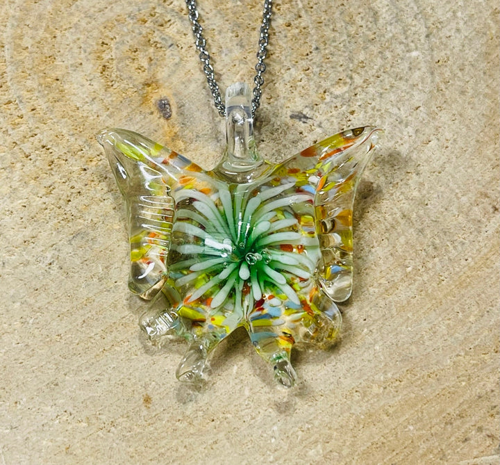 Pendentif en verre en forme de papillon avec fleur à l’intérieur. - Les bijoux de Théa