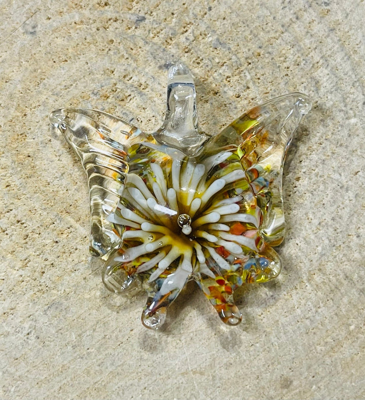 Pendentif en verre en forme de papillon avec fleur à l’intérieur. - Les bijoux de Théa