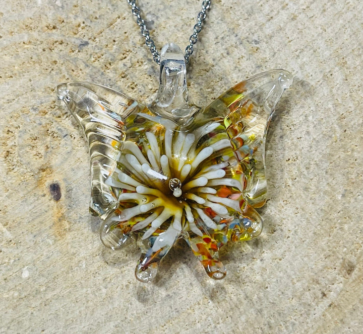 Pendentif en verre en forme de papillon avec fleur à l’intérieur. - Les bijoux de Théa