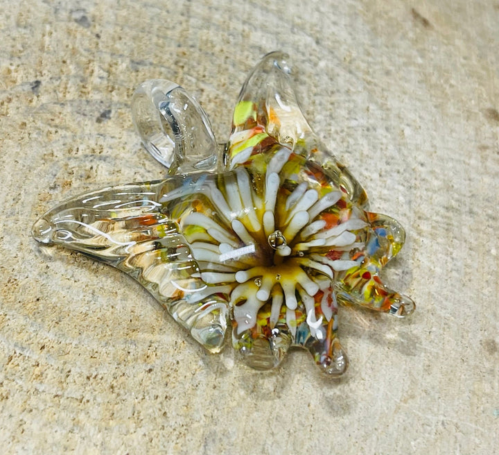 Pendentif en verre en forme de papillon avec fleur à l’intérieur. - Les bijoux de Théa