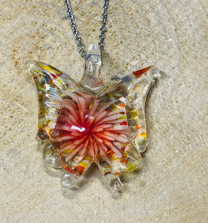 Pendentif en verre en forme de papillon avec fleur à l’intérieur. - Les bijoux de Théa