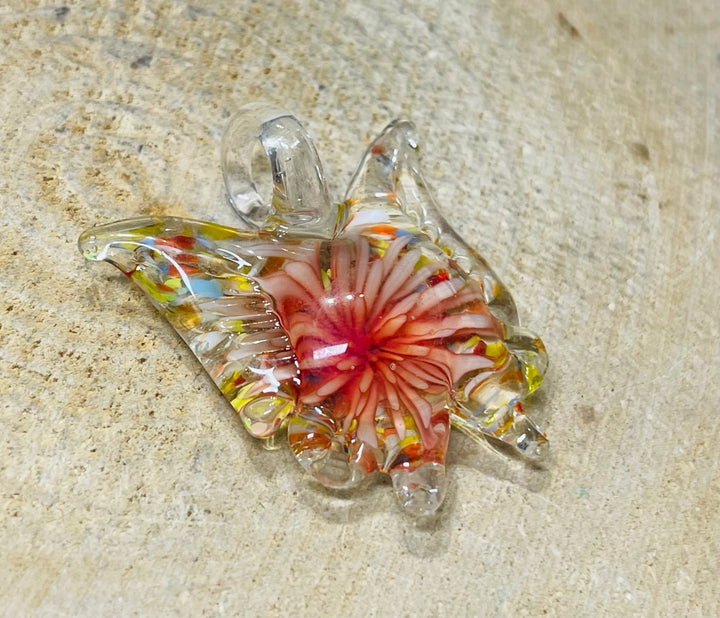 Pendentif en verre en forme de papillon avec fleur à l’intérieur. - Les bijoux de Théa