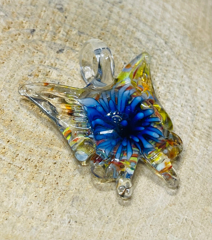 Pendentif en verre en forme de papillon avec fleur à l’intérieur. - Les bijoux de Théa